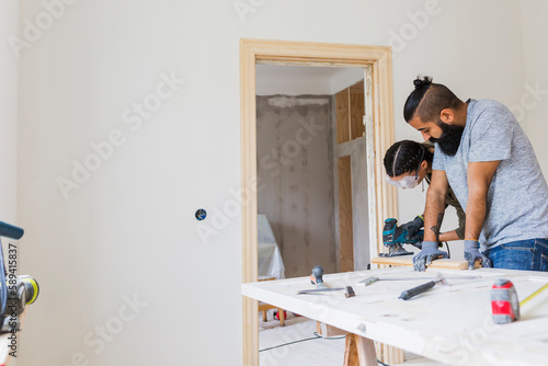 Couple polishing wood during renovation