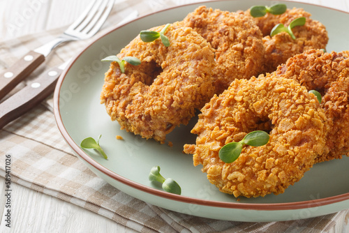 Homemade fried chicken donuts or big nuggets close-up on a plate on the table. Horizontal