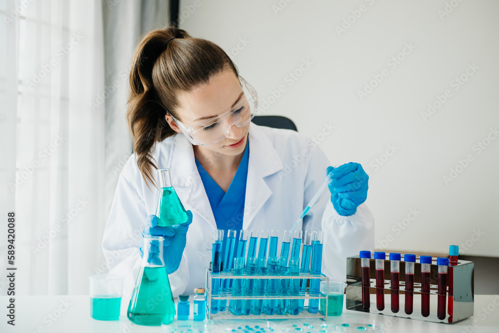 Female biotechnologist testing new chemical substances in a laboratory.. Female biotechnologist testing new chemical substances in a laboratory..
