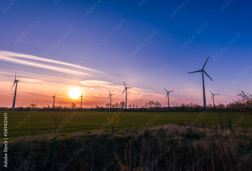 Obraz premium Windräder bei Sonnenaufgang und blauem Himmel