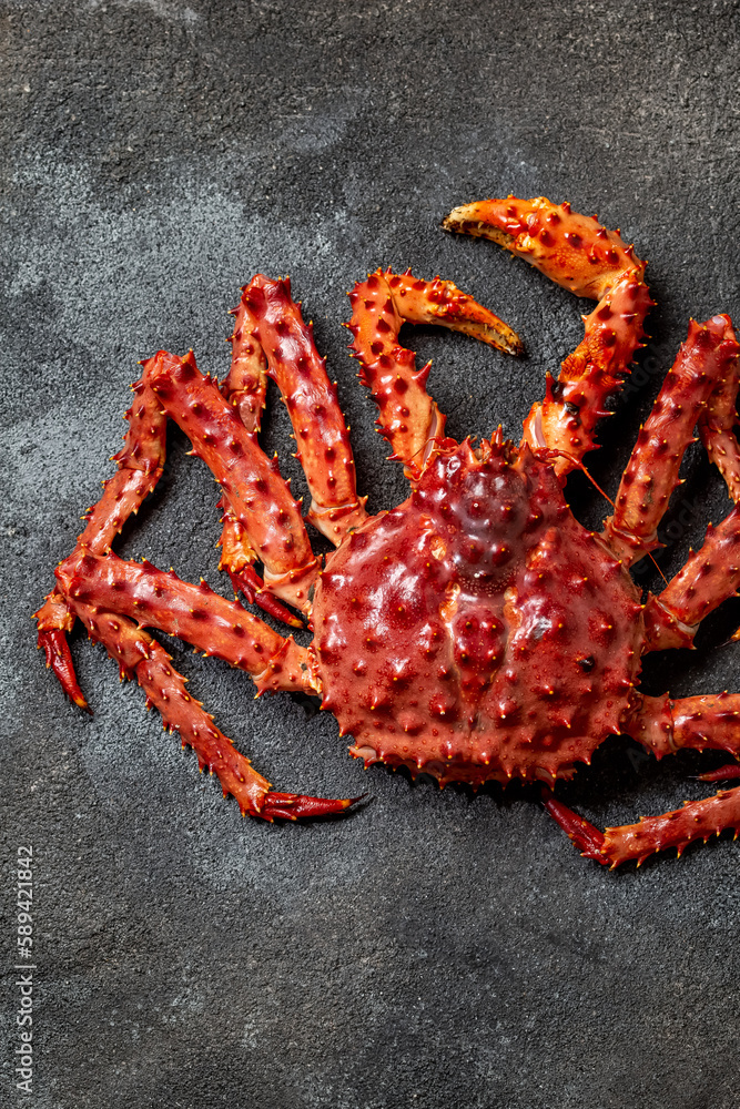 Red king crab on gray background. King crab, lemon and cilantro, top view