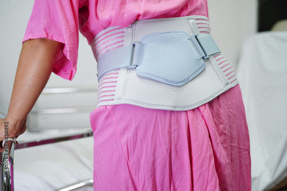 Asian senior pain back wearing elastic support belt with walker. Asian senior pain back wearing elastic support belt with walker.