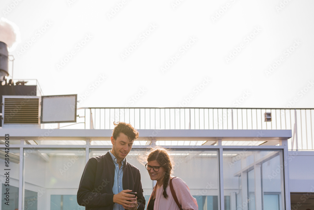 Man and woman standing on ship deck looking at smart phone Man and woman standing on ship deck looking at smart phone