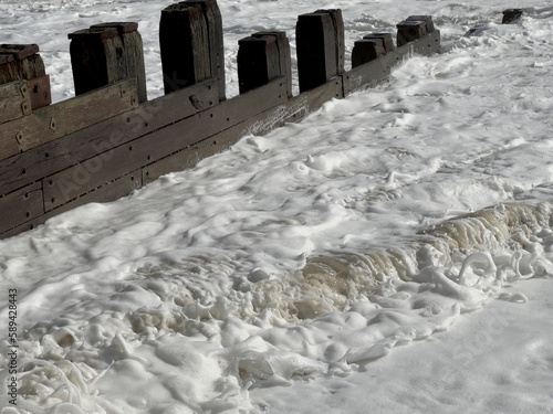 Natural unpolluted sea foam made by air and sand compression in a rising tide
