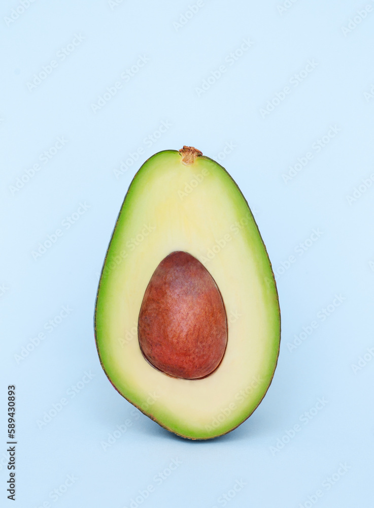 avocado cut in half on a light blue background