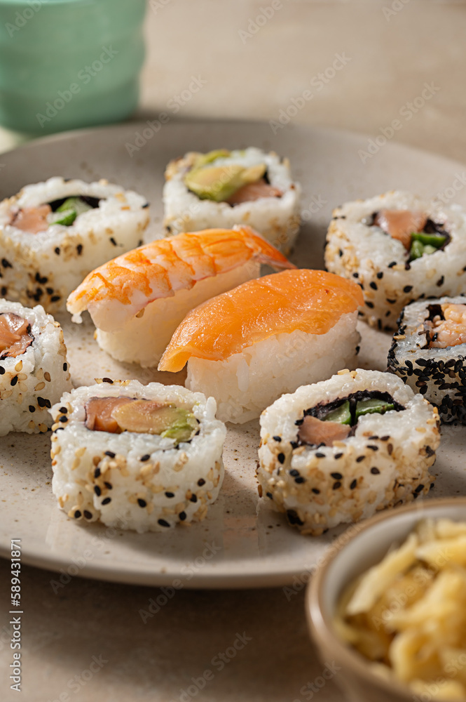 Homemade sushi rolls with salmon, shrimp, avocado i n a round plate Homemade sushi rolls with salmon, shrimp, avocado i n a round plate