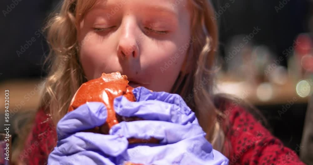 little girl with long hair with pleasure in disposable gloves eats a huge burger. horizontal
little girl with long hair with pleasure in disposable gloves eats a huge burger. horizontal