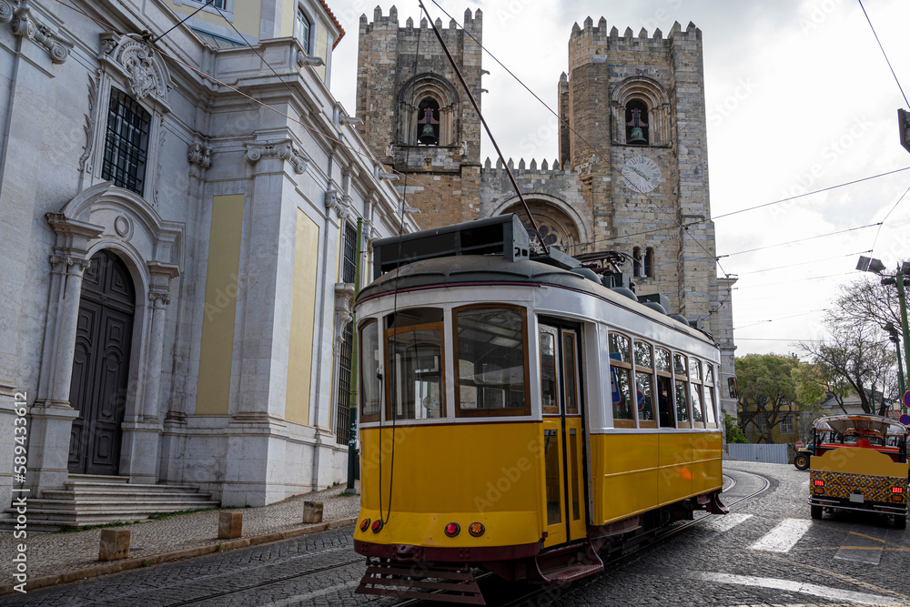 Traditional yellow tram in front of Lisbon Cathedral in Lisbon, Portugal