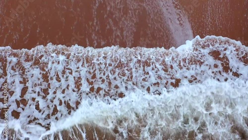 Aerial shot of waves crashing on Scottish beach, St Andrews