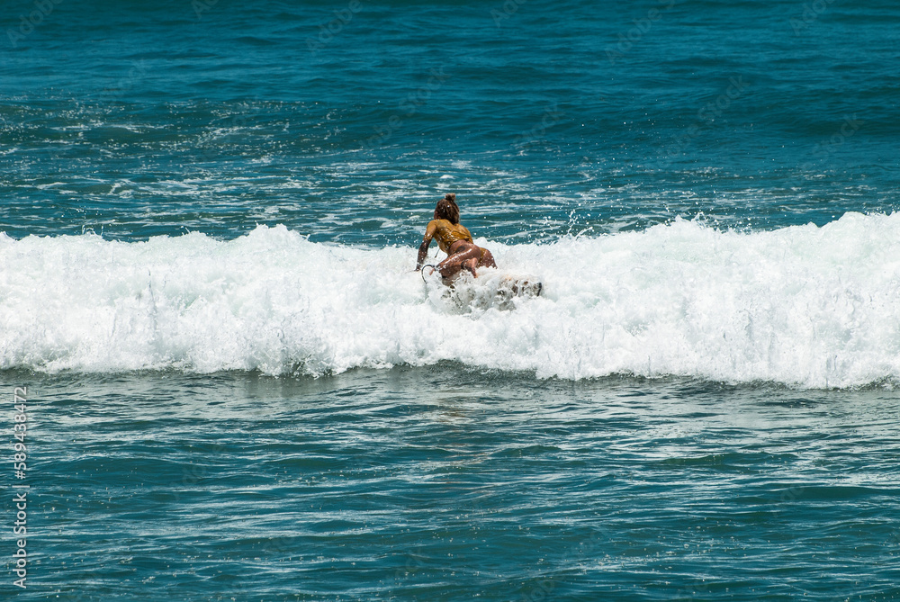Surfers on waves, in Canggu, Bali Island, Indonesia Surfers on waves, in Canggu, Bali Island, Indonesia