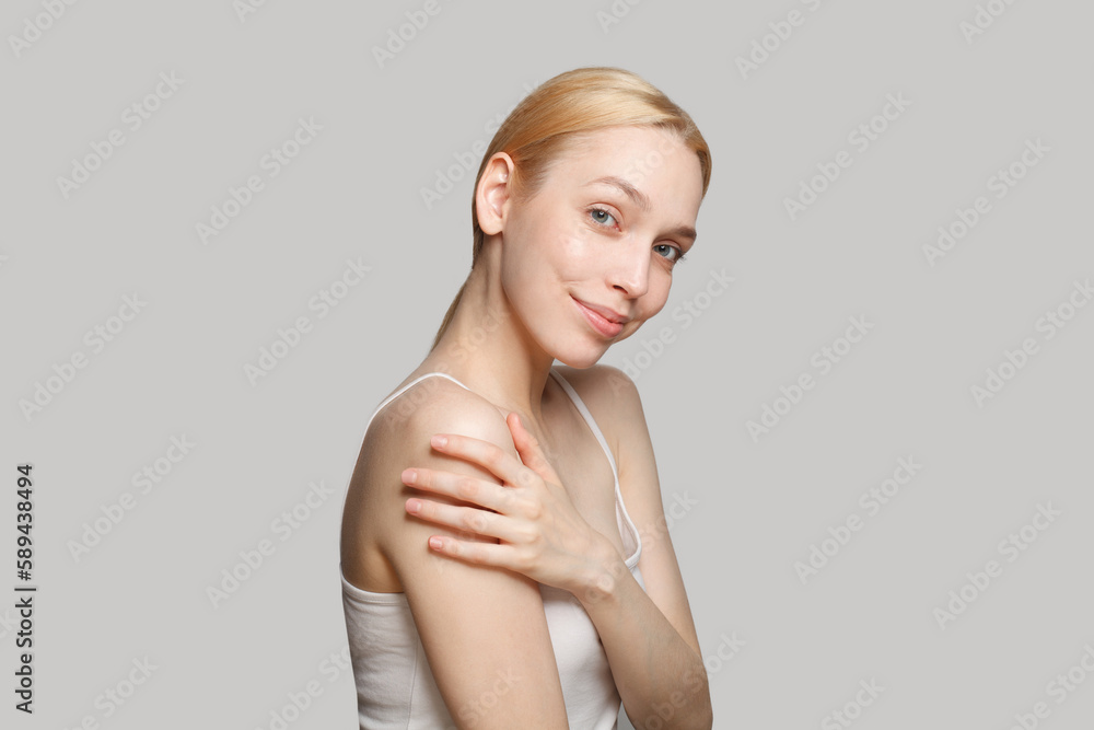 Attractive blonde woman smiling isolated on grey background. Beauty, cosmetics, skincare Attractive blonde woman smiling isolated on grey background. Beauty, cosmetics, skincare
