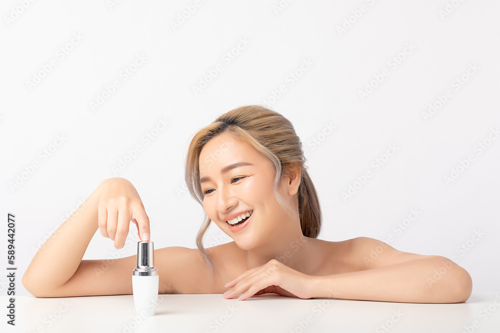 Fototapeta premium Happy beautiful young asian woman holding cosmetic cream blank bottle, Fashion model, Health wellness, Beautiful girl skin care and facial treatment. Isolated on white background.