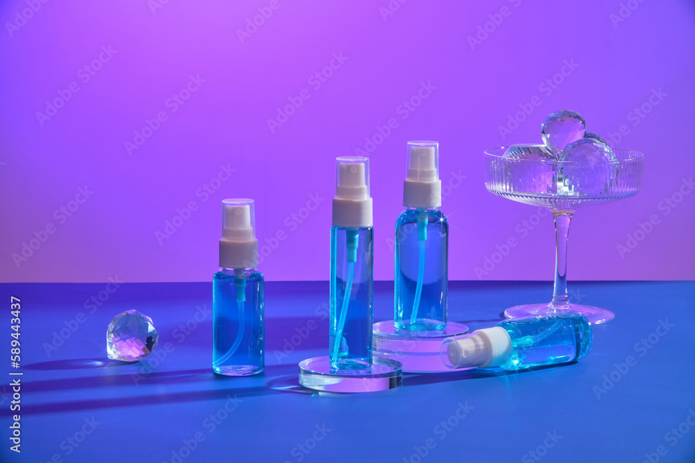 Several mist spray bottles placed on transparent podium, displayed with a glass containing diamond sphere. Cosmetic product branding mockup Several mist spray bottles placed on transparent podium, displayed with a glass containing diamond sphere. Cosmetic product branding mockup