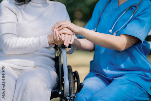 Nurse consulting senior woman holding her hand.