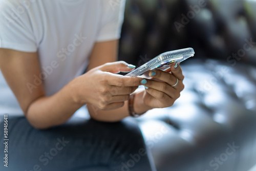 Young girl sitting at home interior and using modern smartphone device.  © Bluesky60