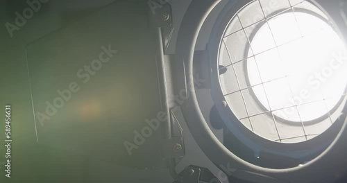 Video studio Fresnel lens spotlight on black background. lights slowly turn on and off. Close up.