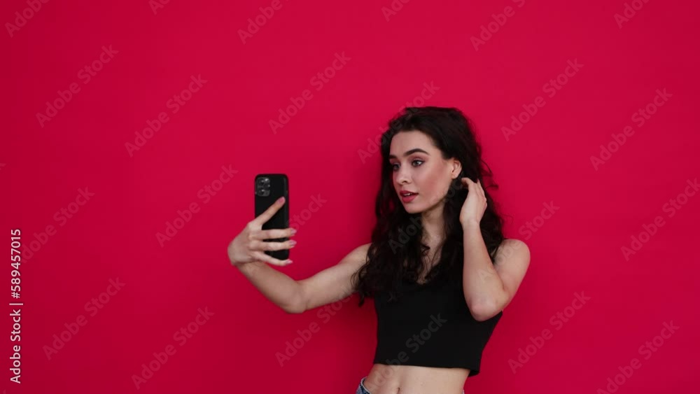Young woman take selfie on the phone isolated on red background Young woman take selfie on the phone isolated on red background