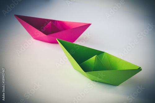 Pink and green paper boat origami isolated on a white background