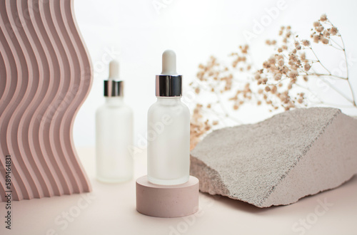 Bottle of essential oil or serum on a light background. Natural cosmetic product.