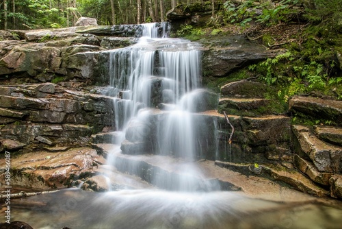 Breathtaking view of foamy waterfall flowing through rocks in the forest  long exposure