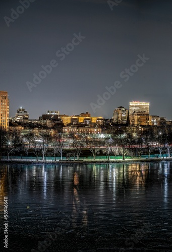 a city lit up at night with a bridge in the foreground © Owl Post Photography/Wirestock Creators