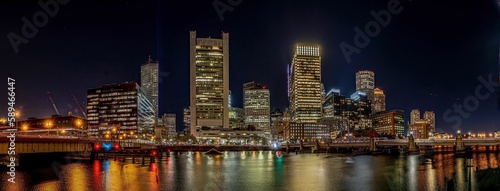 view of city at night, showing lights on buildings and bridge © Owl Post Photography/Wirestock Creators