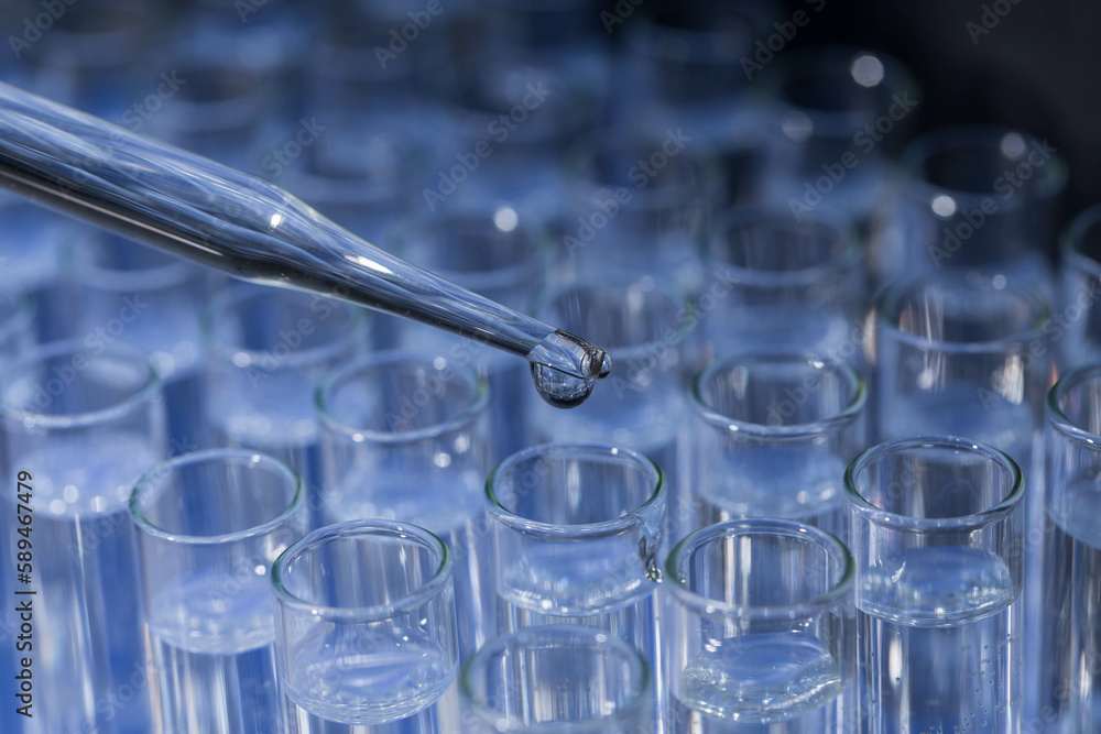 Pipette dropping fluid into test tube Pipette dropping fluid into test tube