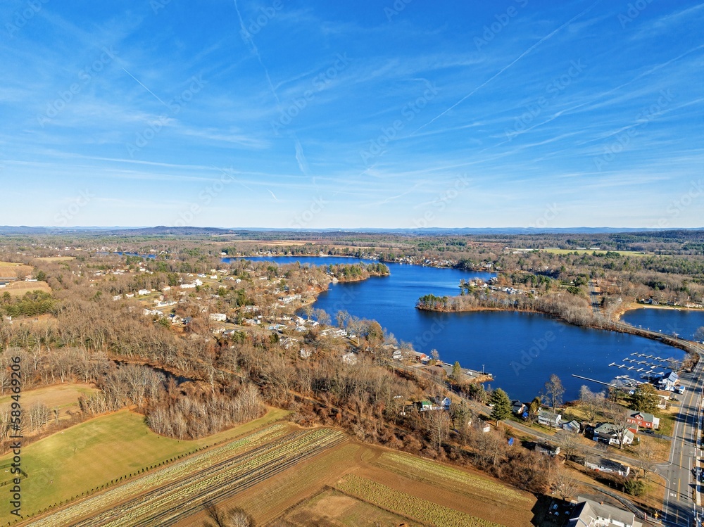 Aerial view of a city, fields, trees and a lake in a sunny day