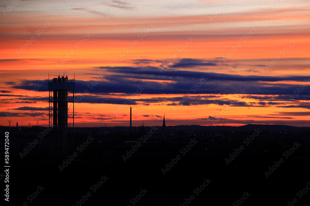 Orange dusk over silhouette of industrial district