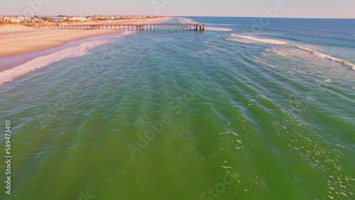 Drone footage of a wooden pier on a sandy beach on a sunny day in Avalon city, New Jersey, USA photo