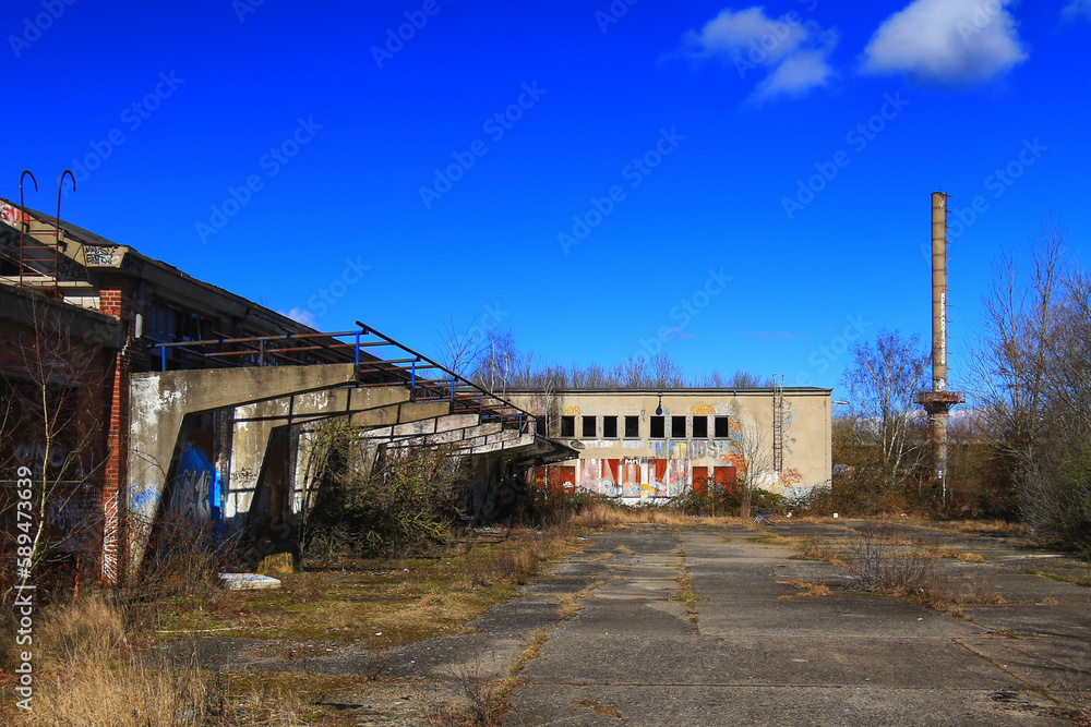 Factory ruins with smokestack on a sunny day in Germany Factory ruins with smokestack on a sunny day in Germany