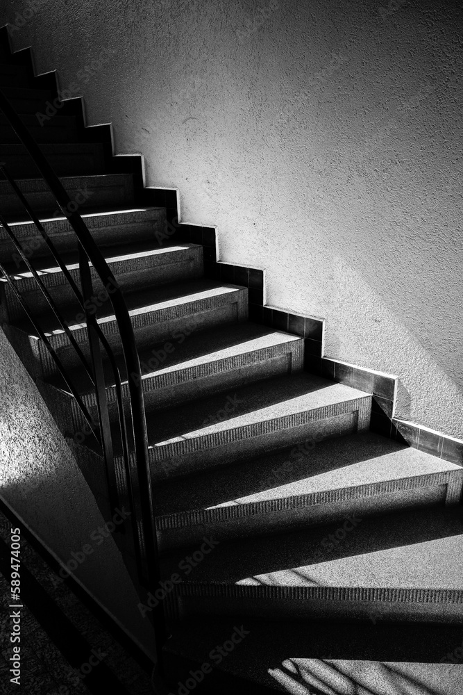 Grayscale vertical shot of stairs inside building Grayscale vertical shot of stairs inside building