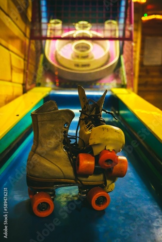 Vertical shot of a pair of old and dirty roller skates at a skating ring © Black Beard1/Wirestock Creators