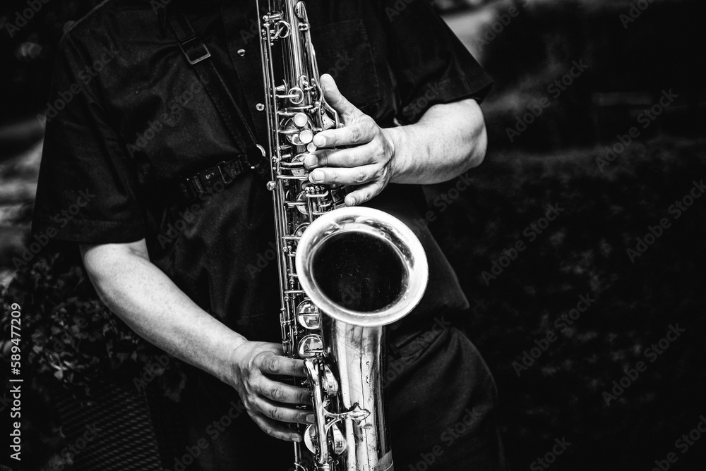 Obraz premium Greyscale shot of a person playing the saxophone