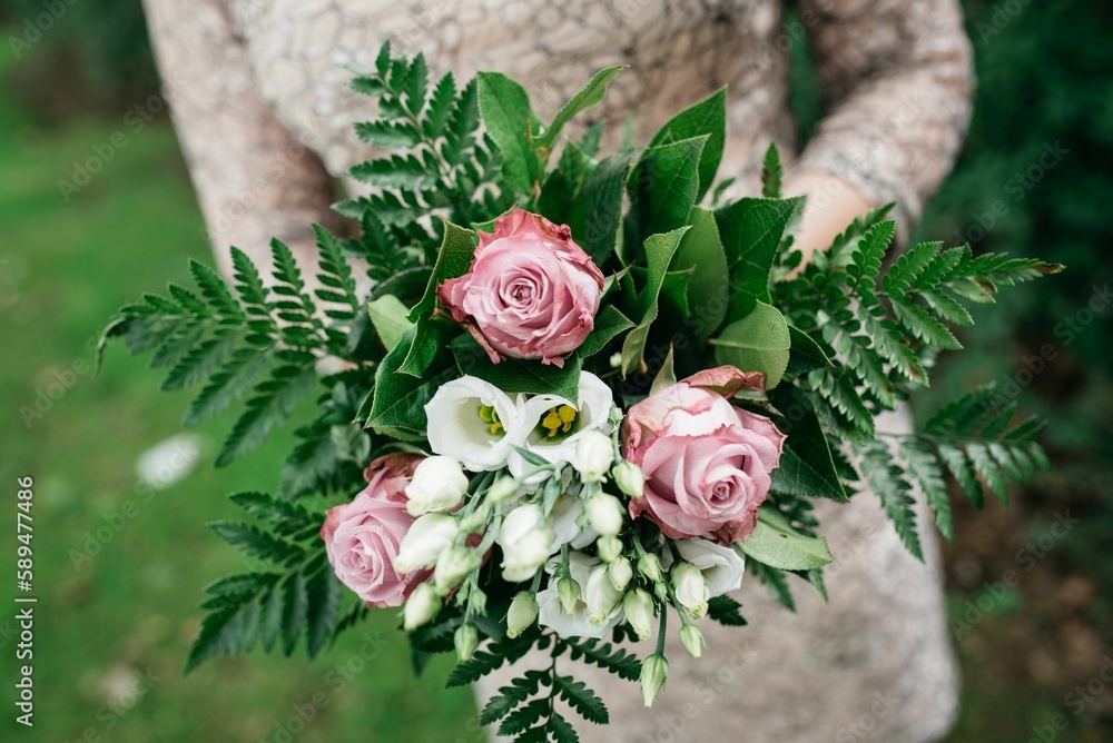 Closeup of a female holding a bouquet indoors with blurred background