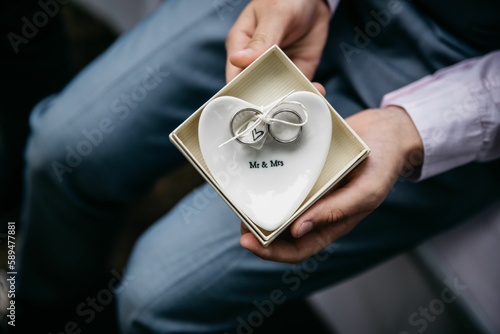 Closeup of male hands holding wedding rings in a special box