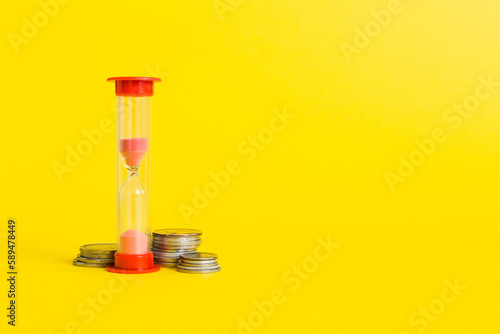 Deadline and time is money concept with hourglass and US coins currency. sand clock time for saving concept