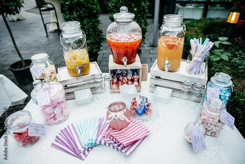 Photography Top view of the drinks dispensers and candy jars with colorful napkins on an out