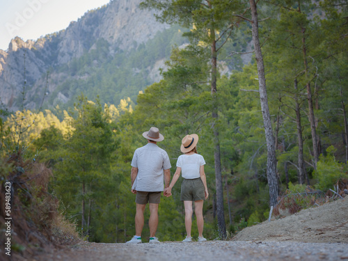 concept of embracing fresh air and engaging in outdoor activities. Loving young couple hugging and smiling together on nature background. Mountains Forest walk in Turkey