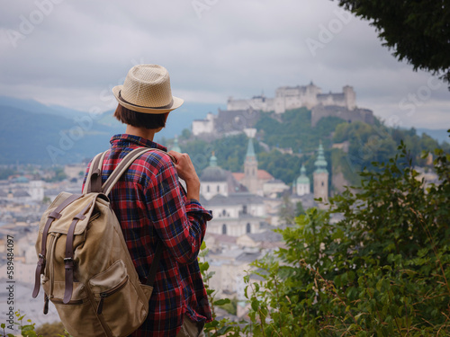 summer female solo trip to Europe, happy young woman walking over Salzburg, trail with viewponts on the old town. Austria summer travel photo