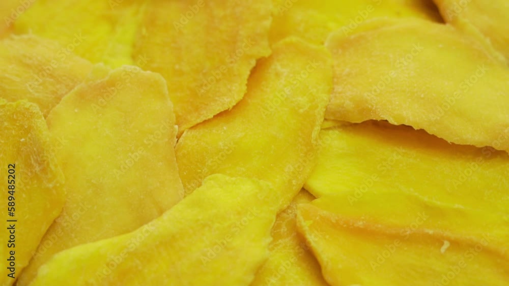 Fresh Slices Of Dried Mango, Close-Up, Rotation, Top View. Isolated Mango Pieces. Background of Yellow Mango Slices. Healthy Food, Vegan Vitamin Diet. Fresh Slices Of Dried Mango, Close-Up, Rotation, Top View. Isolated Mango Pieces. Background of Yellow Mango Slices. Healthy Food, Vegan Vitamin Diet.