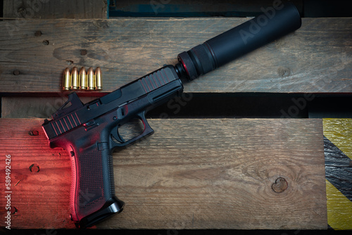 A cool pistol with a silencer and a reflex sight close-up.