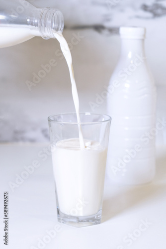 A glass of milk is poured into a glass.