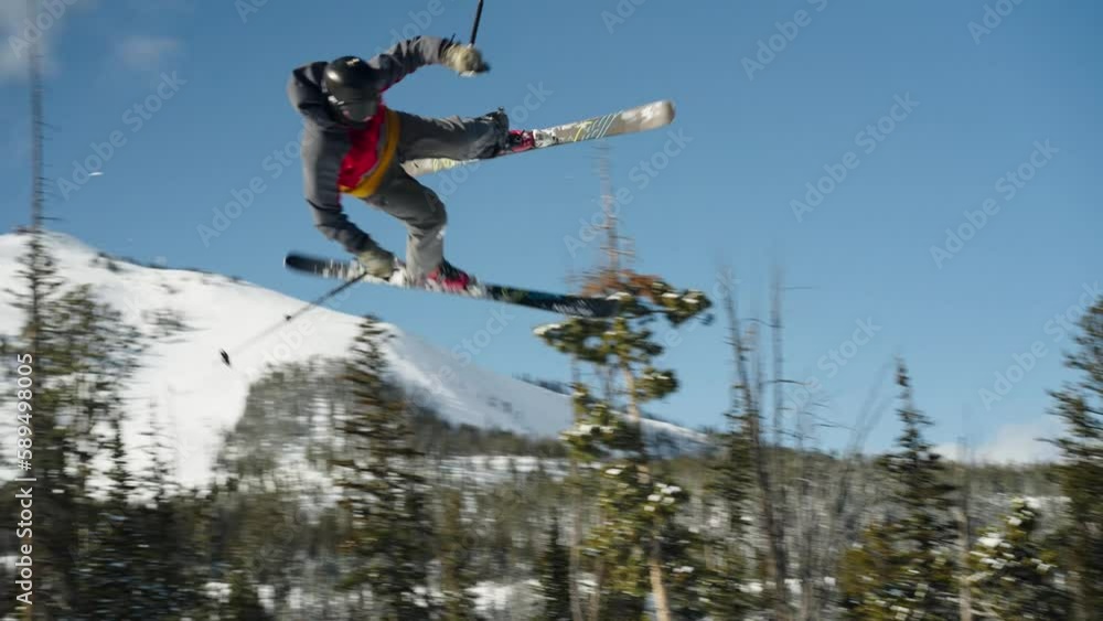 A skier spins and flips over a big jump in Big Sky Montana A skier spins and flips over a big jump in Big Sky Montana