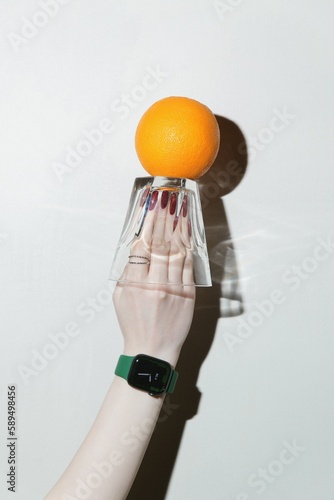 person holding eglass and orange