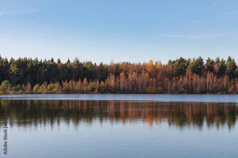 Fototapeta premium Fall colours of forest reflected in the waters of a lake