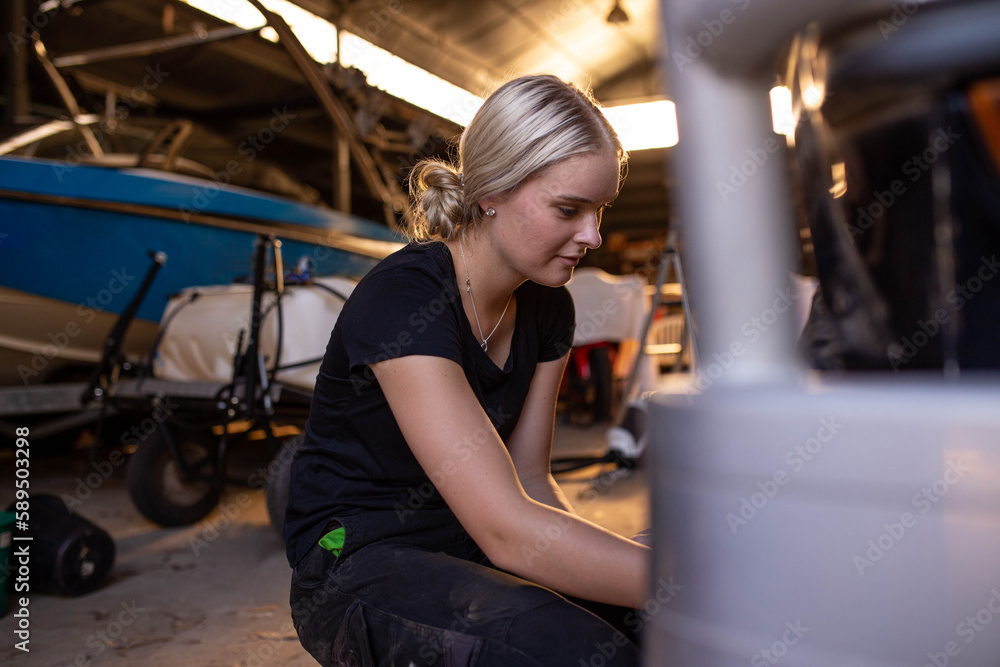 Caucasian woman fixing the tire of a classic SUV in a garage workshop Caucasian woman fixing the tire of a classic SUV in a garage workshop