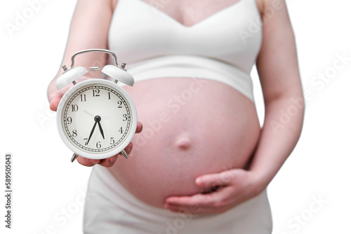 Alarm clock in the hands of a pregnant woman, studio photo, isolated on a white background