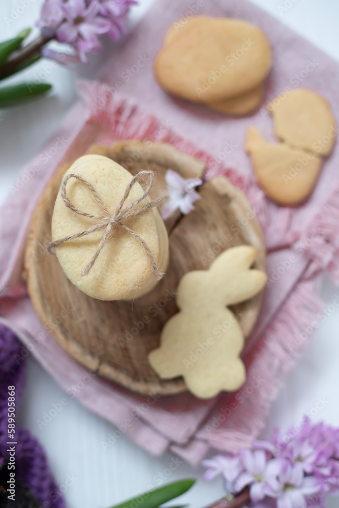 Fototapeta premium Easter cookies in the form of eggs and rabbits, flowers nearby