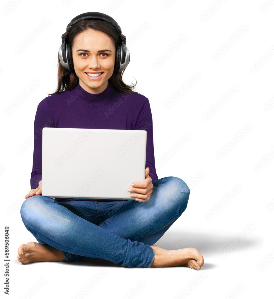 Young woman sitting cross legged with a laptop and headphones on Young woman sitting cross legged with a laptop and headphones on